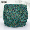 A ball of metallic silk crochet yarn with a teal and silver shimmer texture for knitting and macrame.