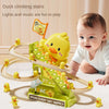 A baby is playing with a yellow duck climbing stairs toy that features lights and music.