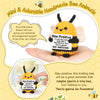 A yellow knitted bee animal figurine with an inspirational card on a hand.