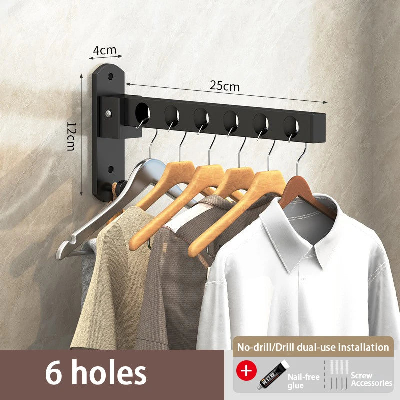 Black foldable wall-mounted clothes drying rack with six holes installed on a beige wall.