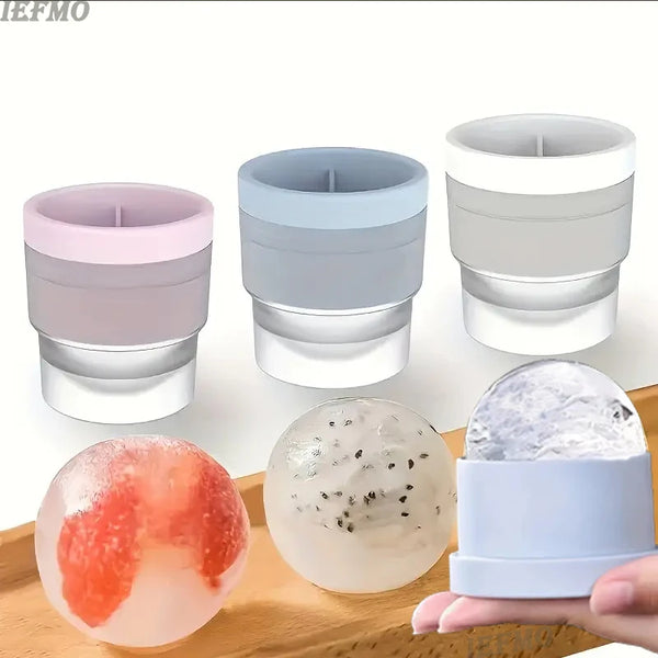 Divers moules à boules de glace en silicone roses, bleues et transparentes sont exposés sur une surface en bois.