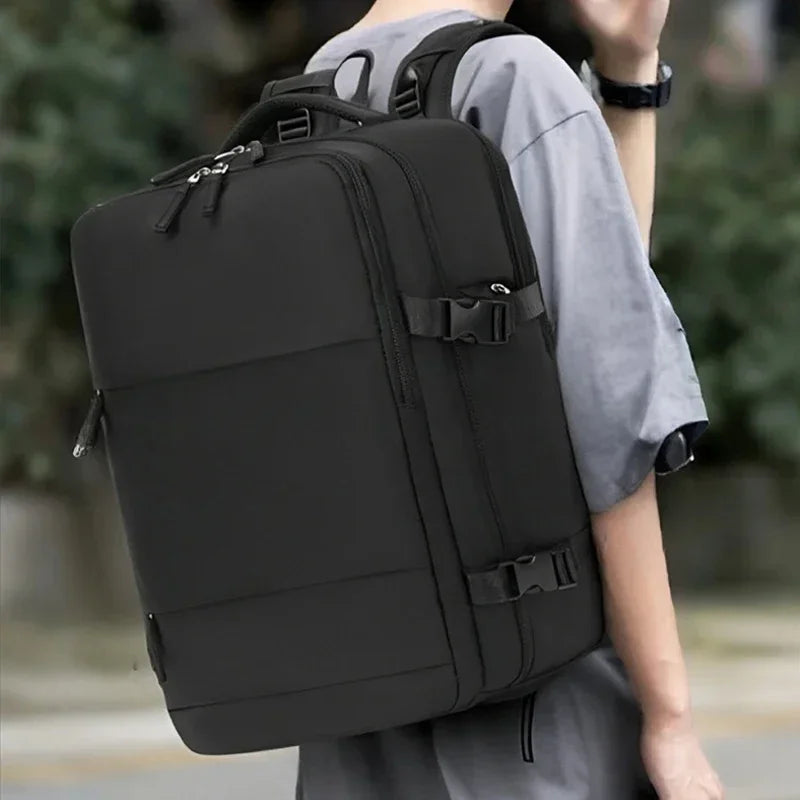 A black durable nylon travel laptop backpack being worn by a person.