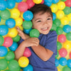 A smiling child holds a large collection of colorful plastic balls in a yellow background.