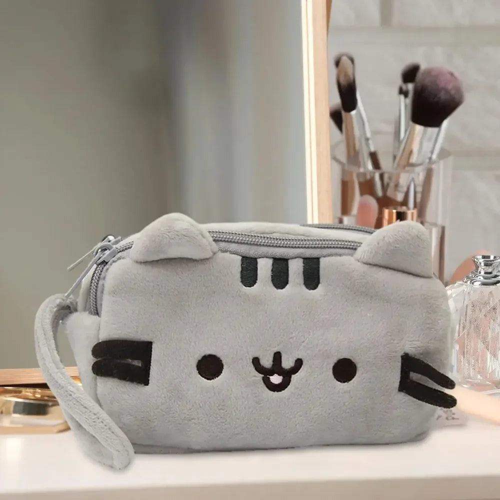 A gray cat plush pencil case with a zipper closure resting on a white surface.