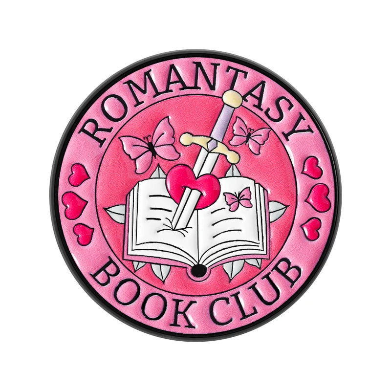 Pink enamel pin featuring a pink butterfly and a silver sword above an open book with a pink heart design.