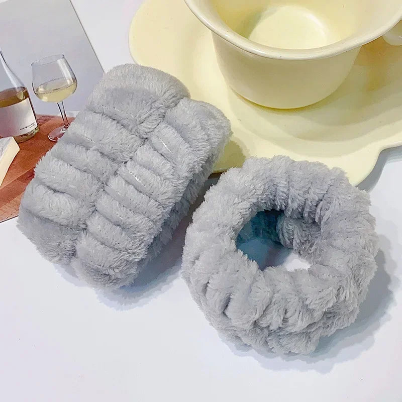 A pair of gray microfiber wrist sweatbands and scrunchies are displayed next to a yellow bowl.