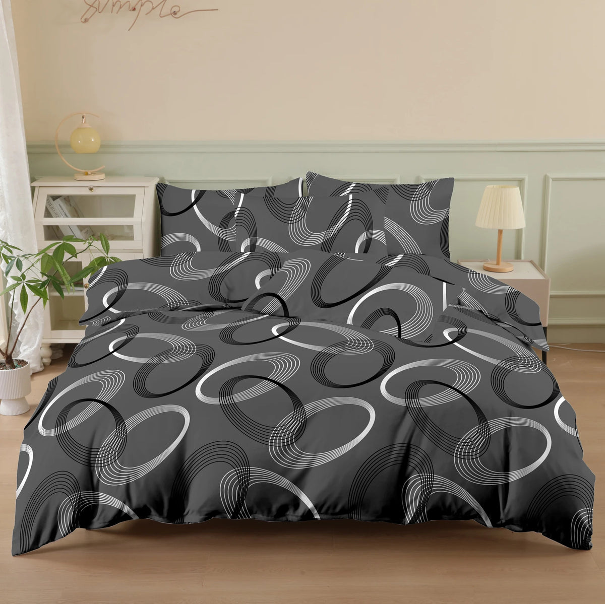 A black duvet cover set with a geometric pattern of concentric white lines and pillows on a bed.
