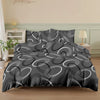 A black duvet cover set with a geometric pattern of concentric white lines and pillows on a bed.