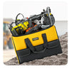 A yellow tool bag filled with various power tools and accessories, resting on a textured surface.