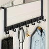 A black over-the-door coat rack with six hooks mounted on a white wall for extra storage.