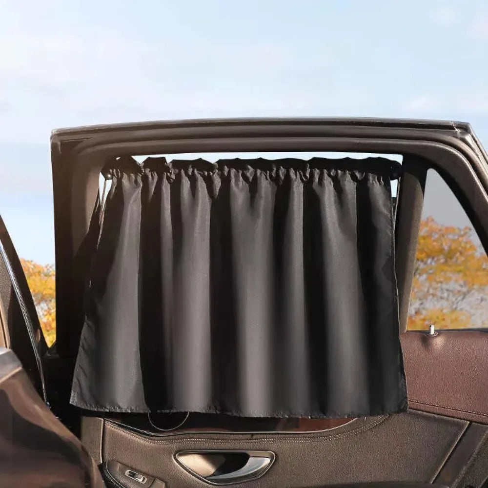 A black sunshade is installed in a car window frame, covering the glass.