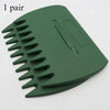 A pair of dark green ergonomic garden leaf clippers or rake with serrated blades.