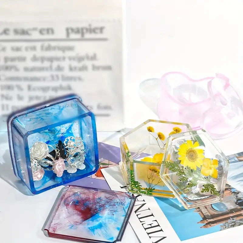 A set of clear resin jewelry boxes with lids, some containing yellow and white flowers.