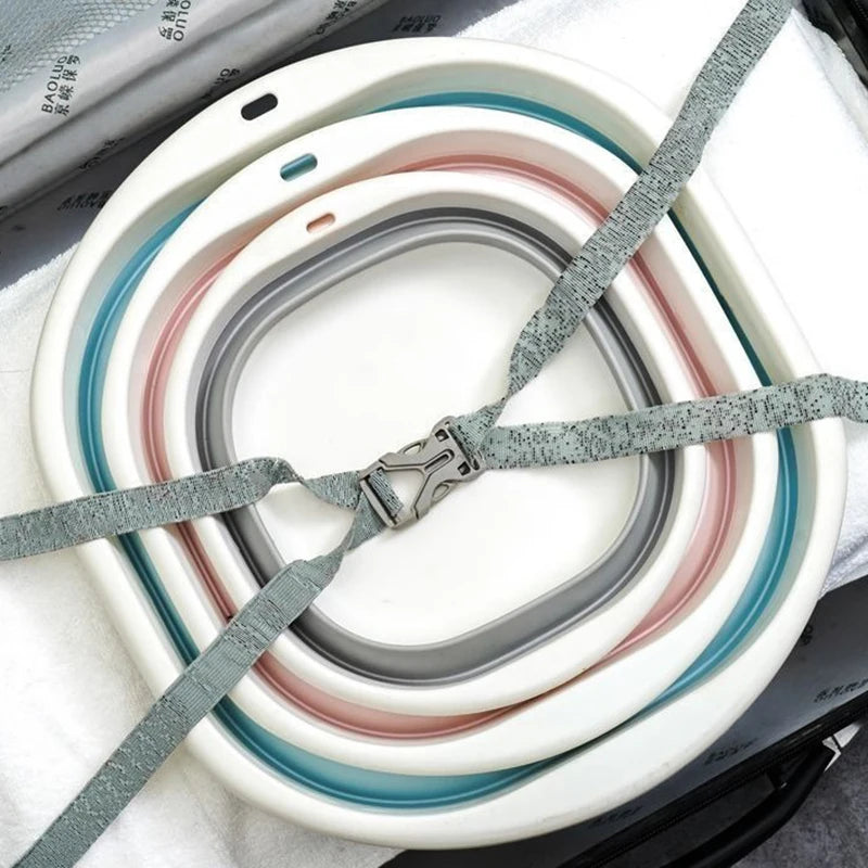 A stack of foldable plastic wash basins in various shades of white, gray, and pink are shown on a white cloth.