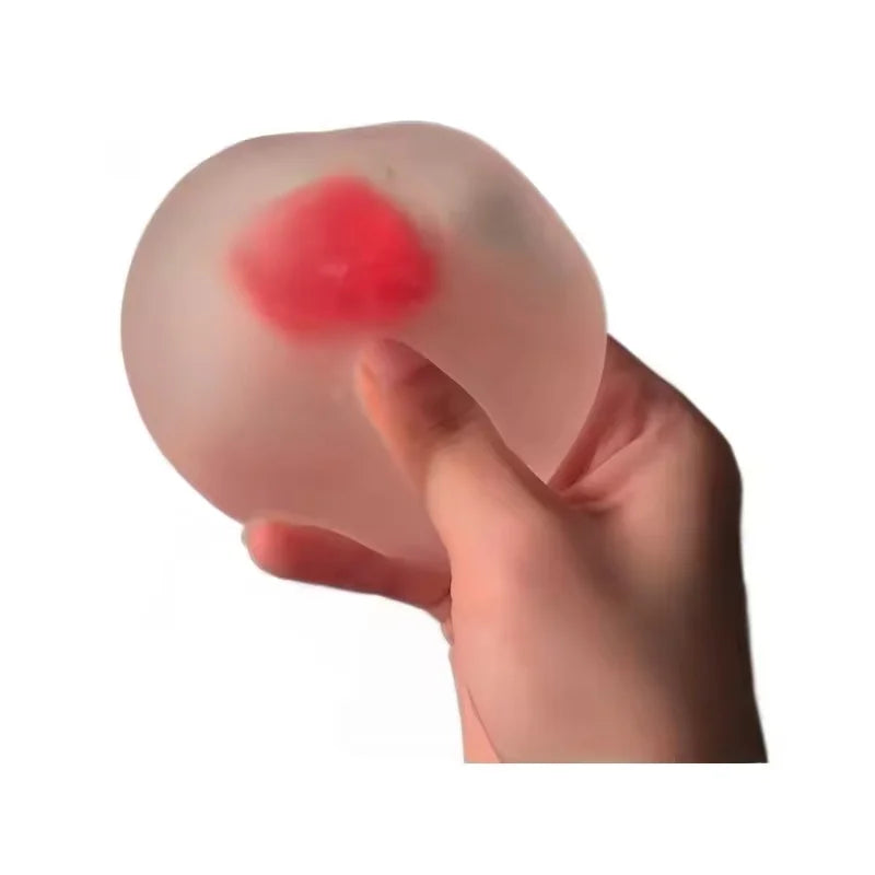 Eine Hand drückt ein rosa, durchsichtiges Stressball-Spielzeug in Form einer Erdbeere.