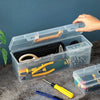 A clear multi-compartment tool organizer box filled with various hand tools and accessories on a dark surface.