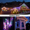 Outdoor decor featuring illuminated fairy string lights decorating a house and garden at night.