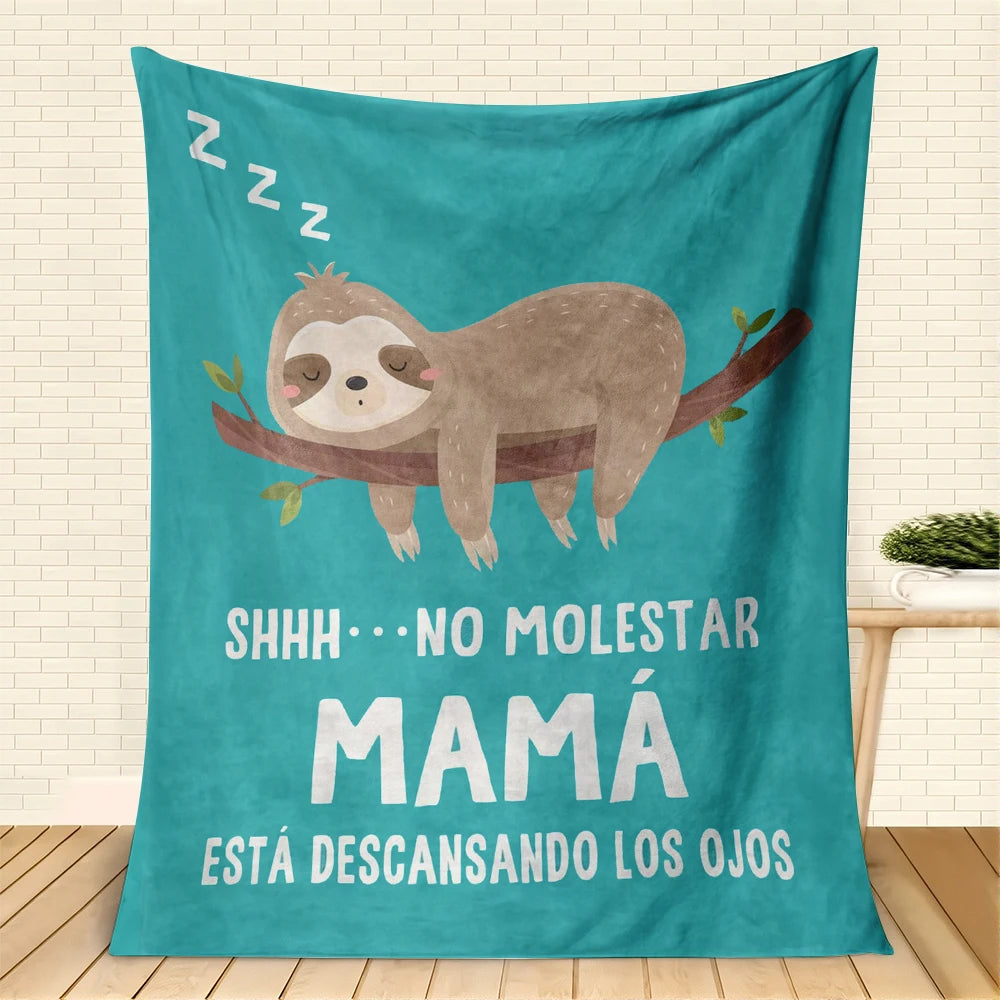 Türkise Decke mit einem Sloth-Bild und spanischer Schrift, die 'Shhh keine Störung Mama ruht' bedeutet
