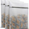 A set of three white reusable mesh laundry bags filled with delicate items.
