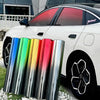 A white car with a red gradient window tint film displayed alongside several colored glass tubes.