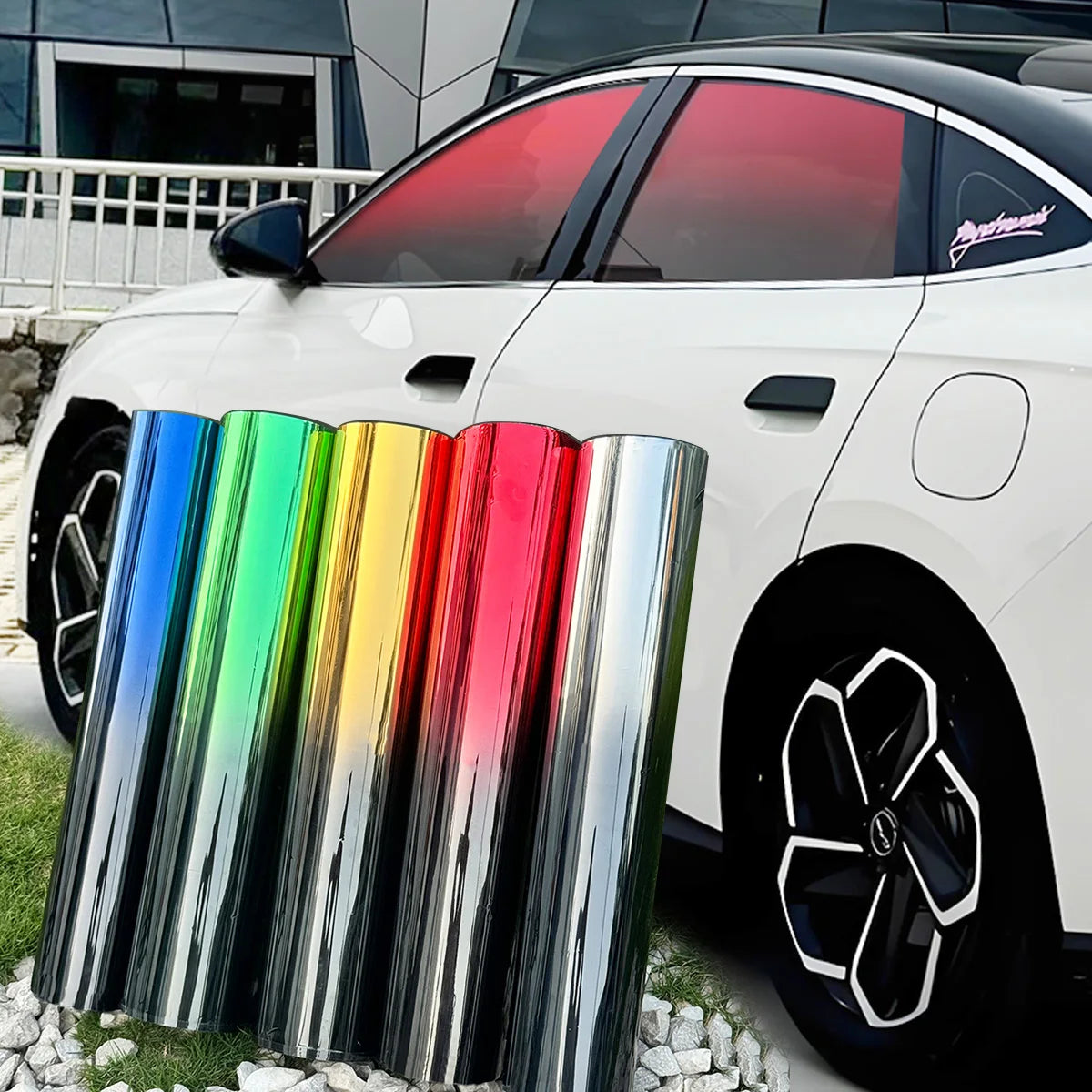 A white car with a red gradient window tint film displayed alongside several colored glass tubes.