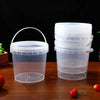 A stack of clear reusable storage containers with handles and leakproof lids on a wooden surface.