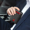 A hand is holding a black slim leather bifold wallet with red accents inside a dark blue suit jacket.