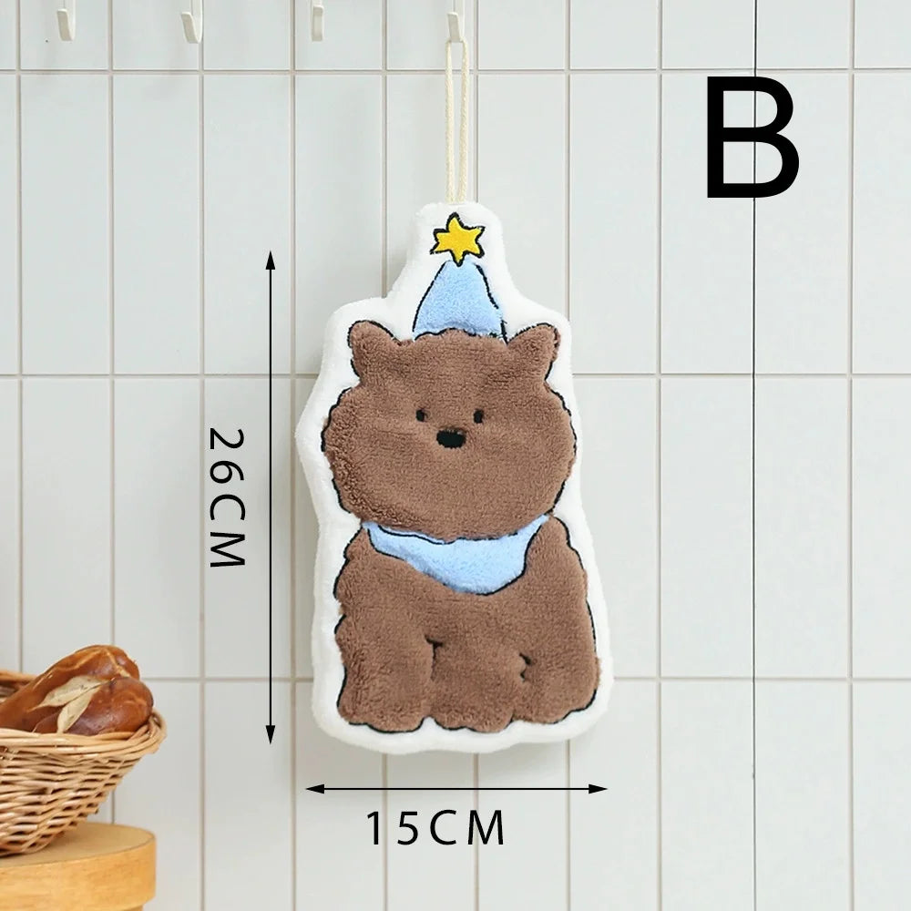 A fluffy brown cartoon bear hanging accessory with a yellow star on a white towel, displayed against a light tiled background