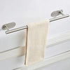 A stainless steel towel holder with a beige textured towel hanging on a white wall.
