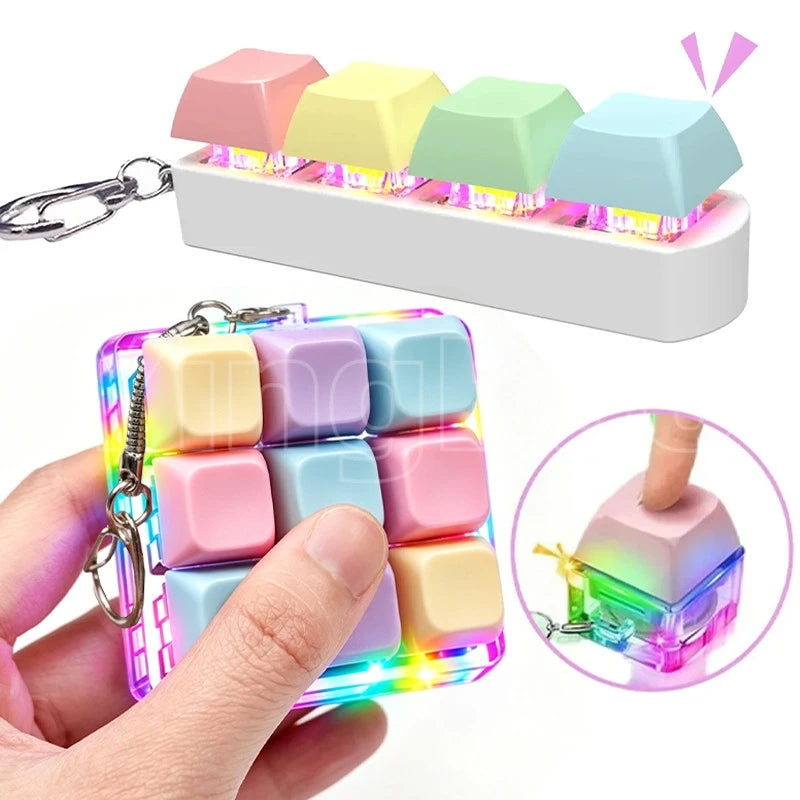 A hand holds a colorful LED macaron keyboard fidget toy with attached keychains and light-up features.