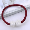 A maroon cord bracelet with two clusters of white pearls displayed on a white background.