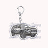 A silver metal key ring attached to a miniature model of an off-road truck.