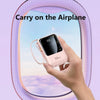 A hand holds a pink portable power bank with a cable and flashlight, set against a blurred sky background.