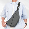 A person is wearing a light blue shirt and carrying a gray practical chest bag with a black strap.