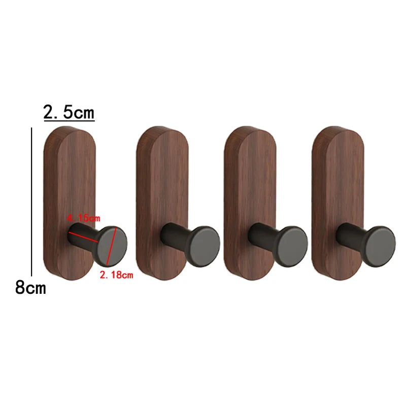 A set of four dark brown walnut wood hooks with round black mounting pieces for organization.