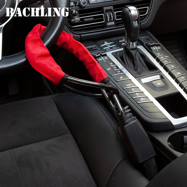 A red anti-theft lock is visible on a black steering wheel and seat belt in a car interior.