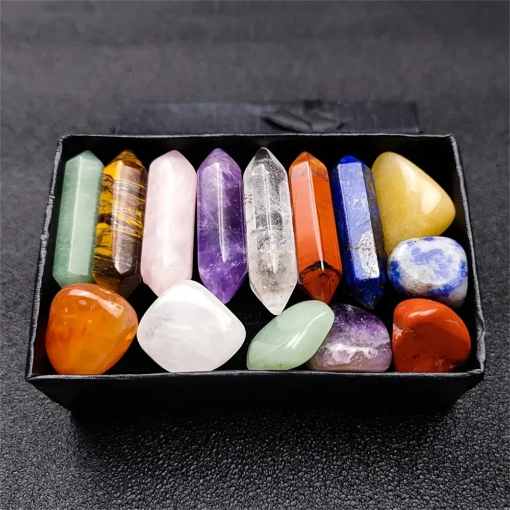 Eine Sammlung von vierzehn farbigen Kristallen, darunter Rosenquarz, in einer schwarzen Box.