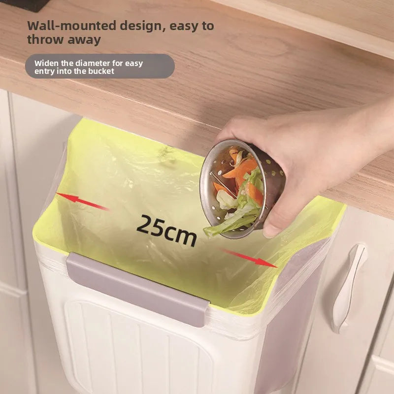 A hand is placing a metal bowl into a yellow, wall-mounted trash bin for easy disposal.