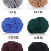 A collection of chunky acrylic yarn skeins in various colors and textures, including gray, beige, blue, green, maroon, and bl