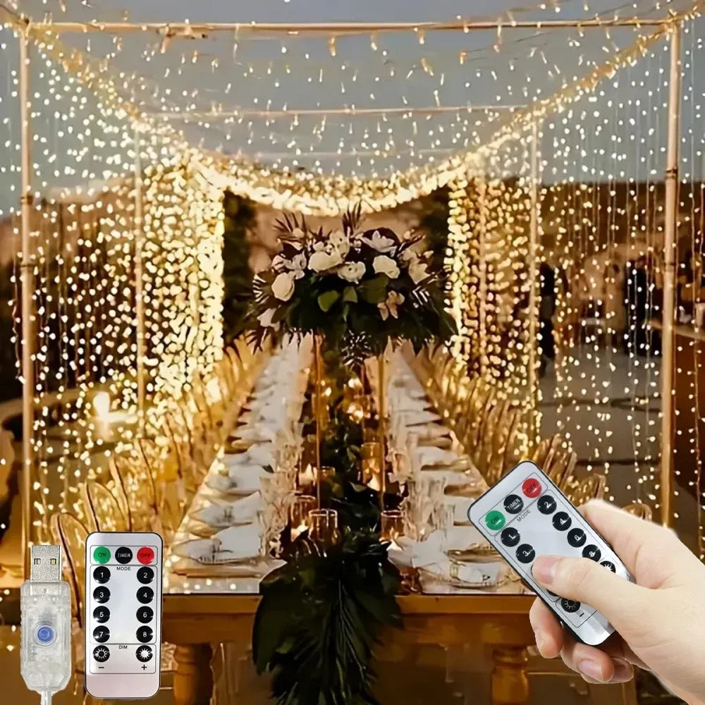 A hand holds a remote control for LED curtain string lights with fairy lights decorating an indoor display.
