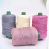 Sammlung von 3mm Strickfäden aus Eisrope in rosa, beige und grau auf Spulen für DIY-Bastelarbeiten.