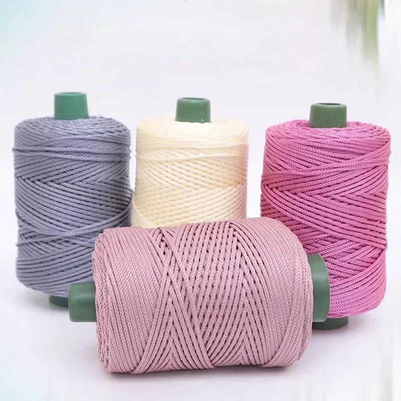 Sammlung von 3mm Strickfäden aus Eisrope in rosa, beige und grau auf Spulen für DIY-Bastelarbeiten.