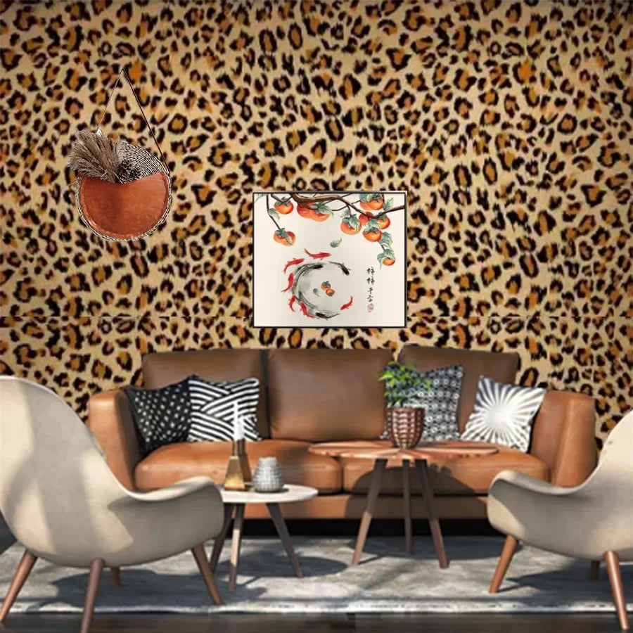 A living room wall covered in leopard print self-adhesive wallpaper with a brown leather sofa and decorative pillows.