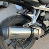 A close-up view of a silver universal dirt bike exhaust guard mounted on a motorcycle.