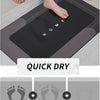 A black natural diatomium mud floor mat is shown being used in a bathroom, with a quick dry feature highlighted.