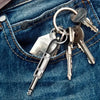 A set of vintage-style wall keys and a silver pen attached to a keyring, resting in a blue denim pocket.
