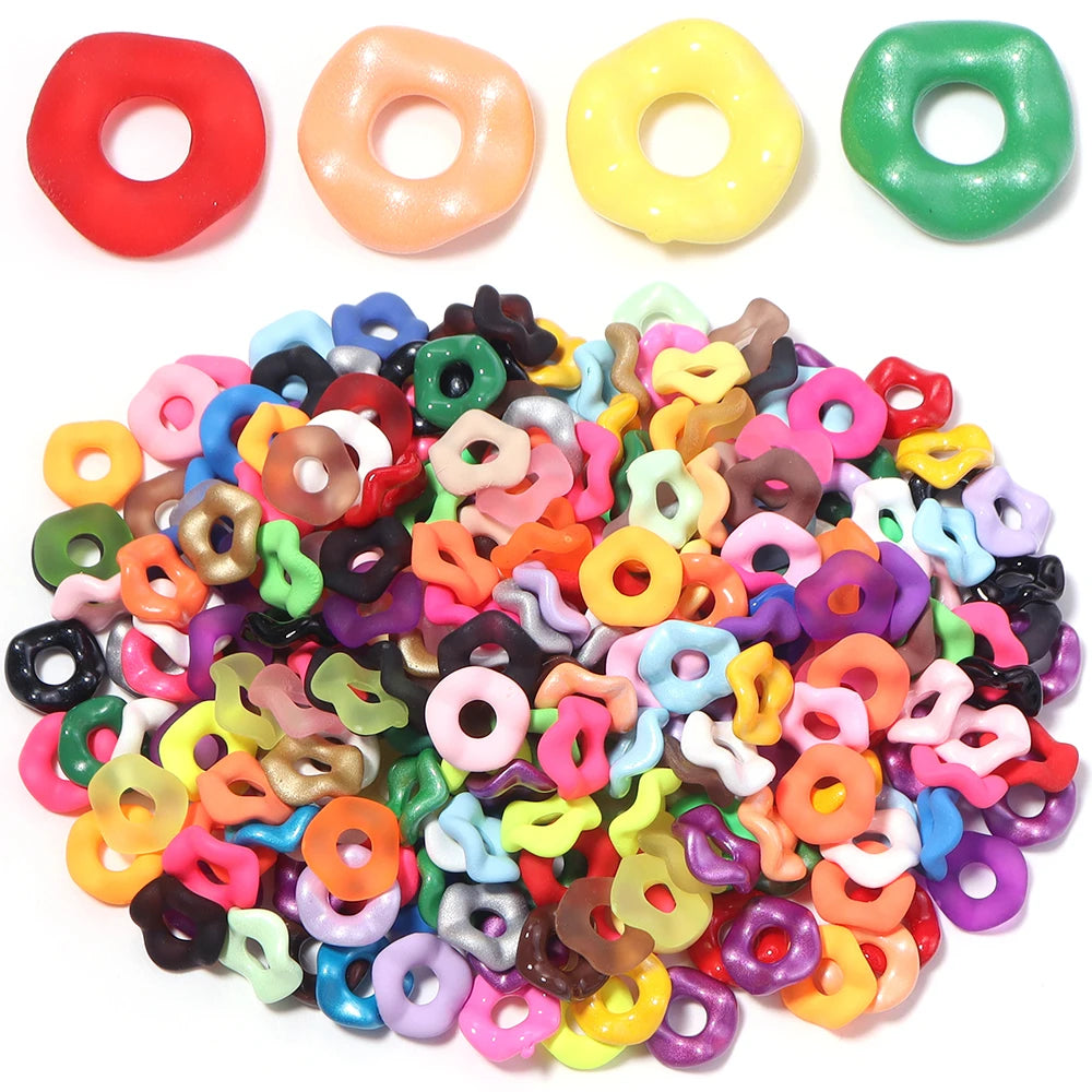 A collection of colorful acrylic spacer beads in various shapes and wave patterns for jewelry making