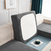 A gray stretch jacquard sofa cover with a white back cushion displayed on a light-colored sofa.