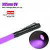 A black mini flashlight with a pen clip is shown emitting a purple UV light.