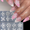 A hand displays pink and white floral nail art created using silicone molds on fingernails.